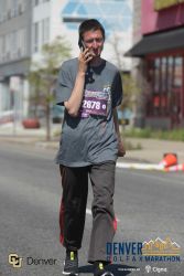 Daniel talking on the phone during the 2022 Denver Colfax Marathon.